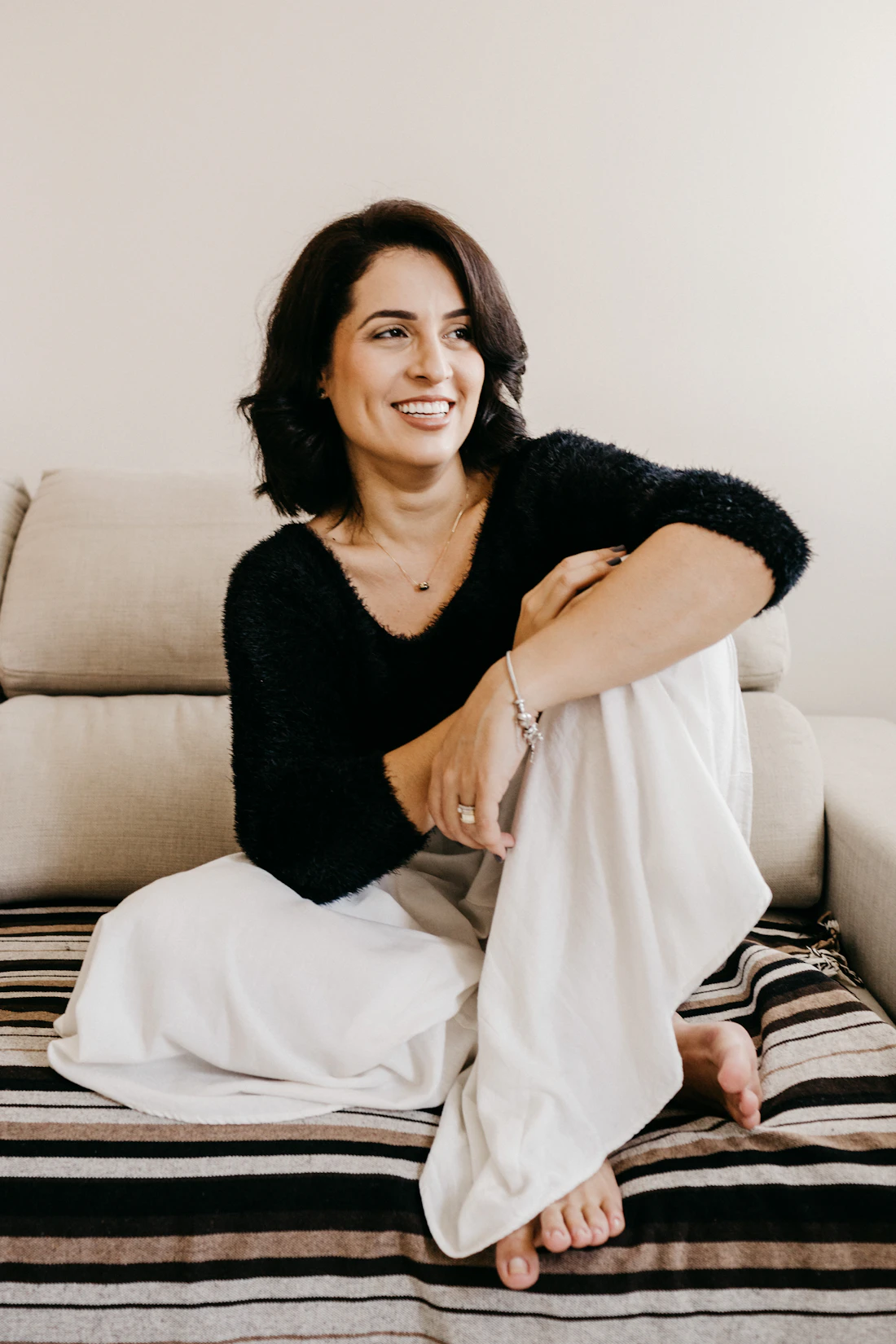 A woman in her forties smiling, relaxed at home